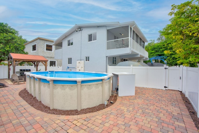 view of swimming pool with a gazebo and a sunroom