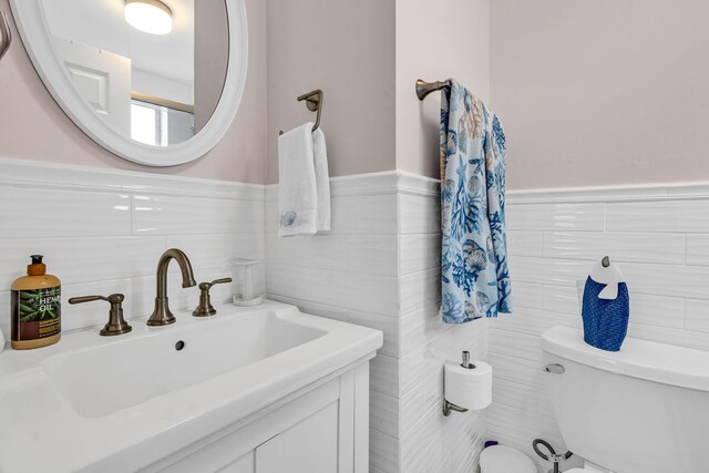 bathroom with tile walls, sink, and toilet