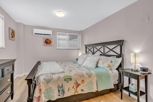 bedroom featuring a wall unit AC and light hardwood / wood-style flooring