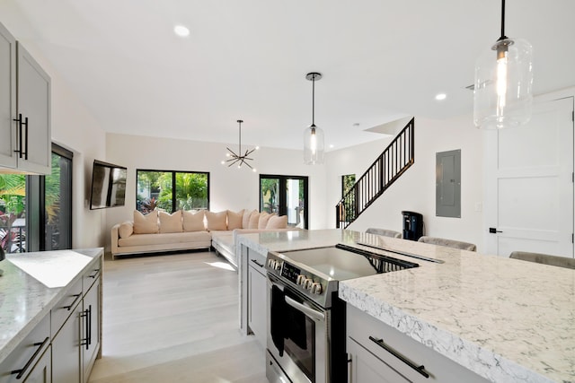 kitchen with gray cabinets, stainless steel electric range oven, electric panel, light stone counters, and light hardwood / wood-style floors