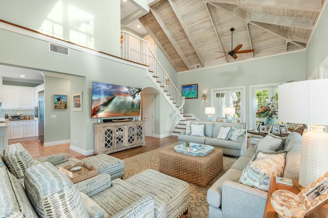 tiled living room with wood ceiling, ceiling fan, high vaulted ceiling, and beamed ceiling