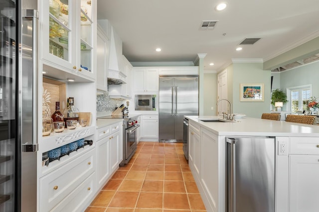 kitchen featuring sink, white cabinets, decorative backsplash, built in appliances, and light tile patterned floors