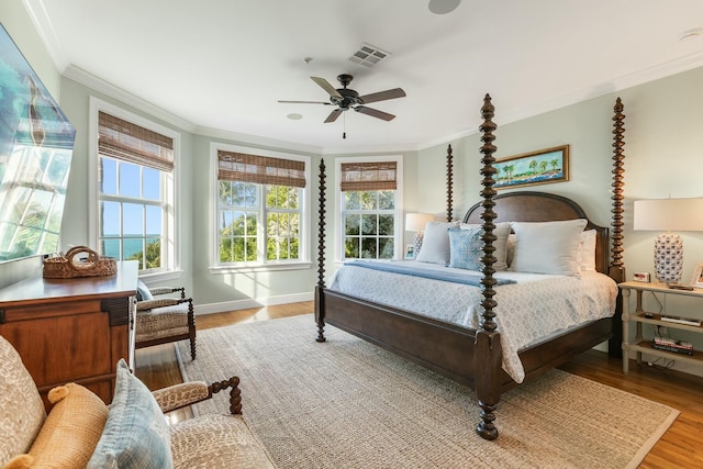 bedroom with ornamental molding, wood-type flooring, and ceiling fan