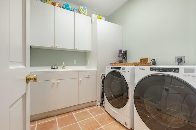 washroom featuring sink, light tile patterned floors, cabinets, and washing machine and clothes dryer