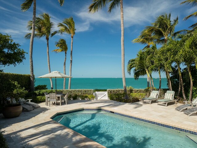 view of pool with a patio and a water view