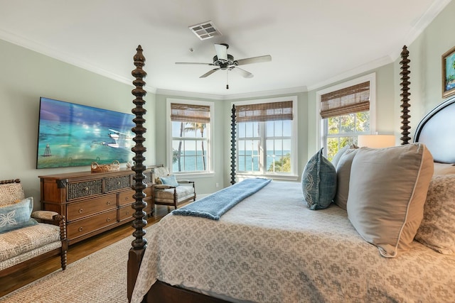 bedroom featuring multiple windows, crown molding, and hardwood / wood-style flooring