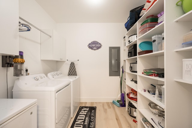 laundry area featuring separate washer and dryer, light hardwood / wood-style flooring, electric panel, and cabinets