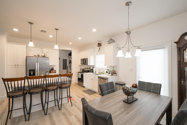 dining room with sink and light hardwood / wood-style flooring