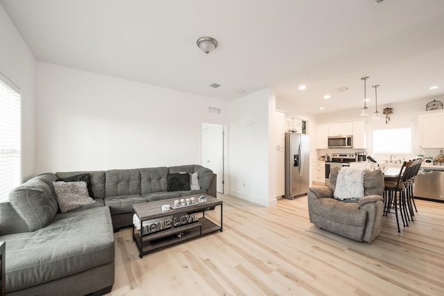 living room with sink and light wood-type flooring