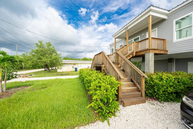 view of side of property featuring a wooden deck and a lawn