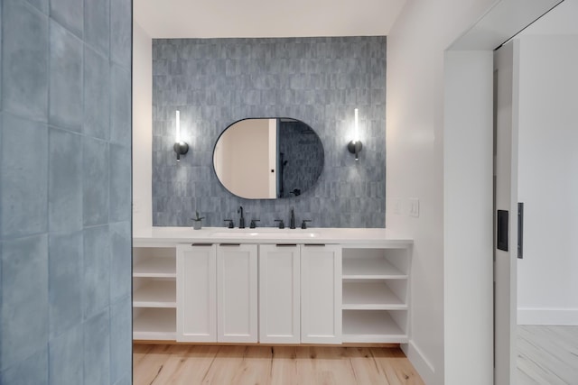 bathroom featuring hardwood / wood-style floors, vanity, and tile walls