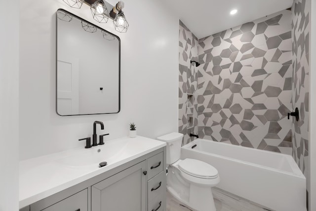 full bathroom featuring vanity, tiled shower / bath combo, and toilet