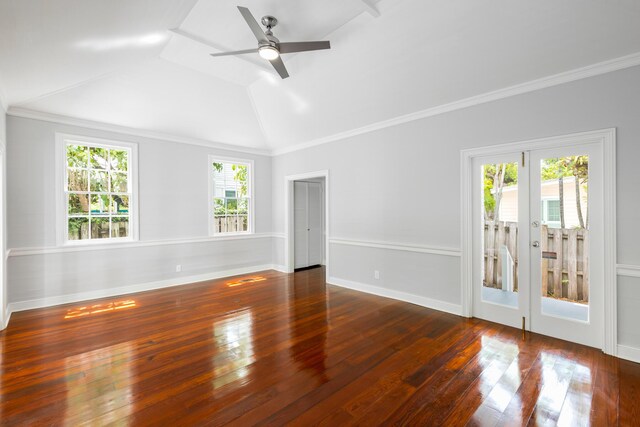 empty room with dark wood-type flooring, ornamental molding, ceiling fan, and vaulted ceiling