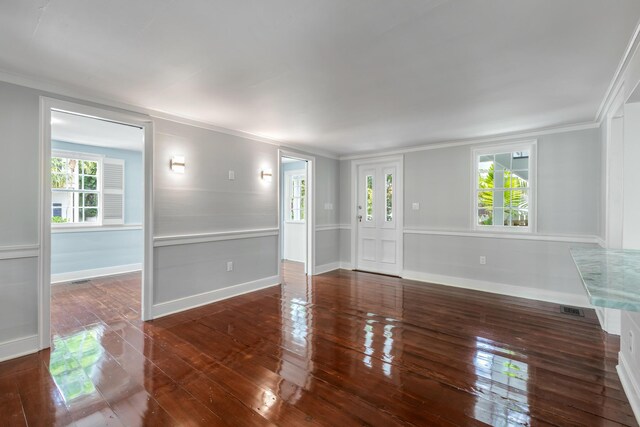 empty room featuring dark hardwood / wood-style flooring and ornamental molding