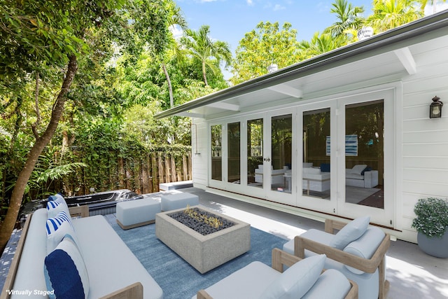 view of patio / terrace with french doors and an outdoor living space with a fire pit