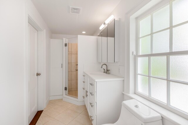 bathroom featuring vanity, tile patterned floors, toilet, and walk in shower