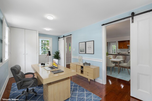 office space with a barn door and dark hardwood / wood-style floors