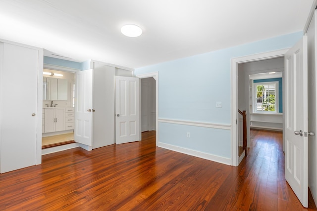 unfurnished bedroom with dark wood-type flooring and sink