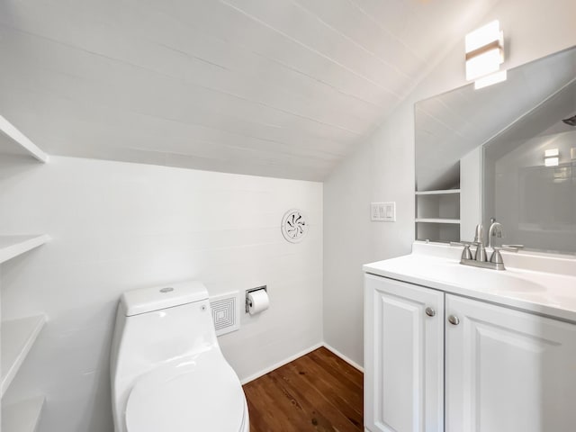 bathroom with wood-type flooring, toilet, vaulted ceiling, and vanity