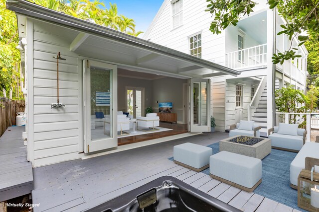 deck featuring an outdoor living space with a fire pit