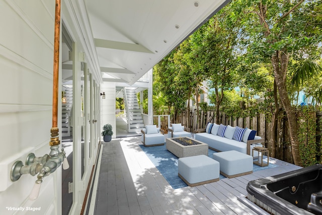 deck with an outdoor living space with a fire pit