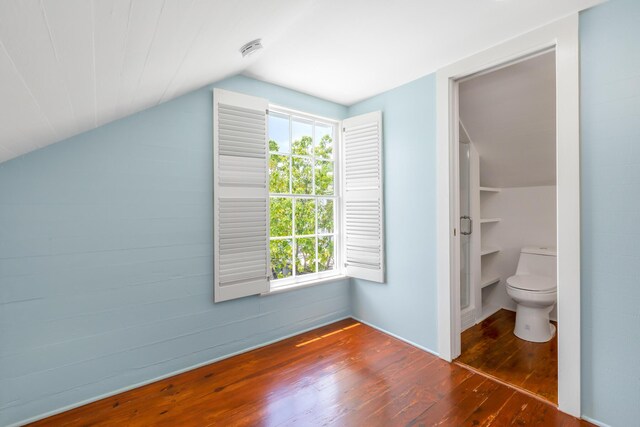 bonus room with vaulted ceiling and dark hardwood / wood-style floors