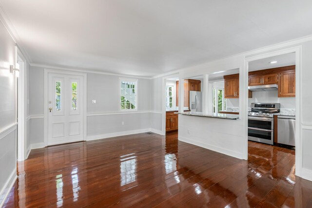 unfurnished living room with ornamental molding, dark hardwood / wood-style floors, and a wealth of natural light