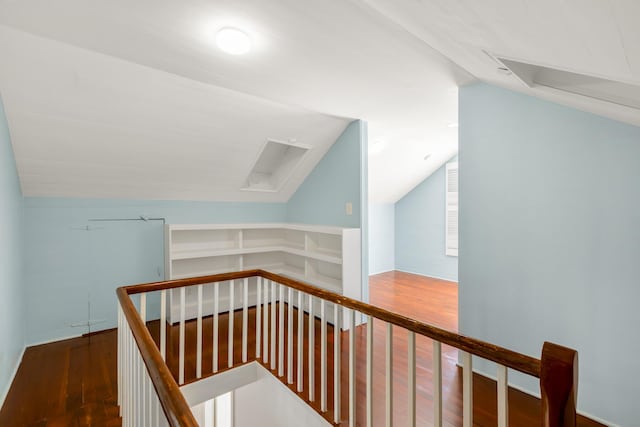 stairway featuring wood-type flooring and vaulted ceiling