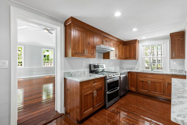 kitchen featuring sink, ornamental molding, stainless steel appliances, light stone countertops, and dark wood-type flooring