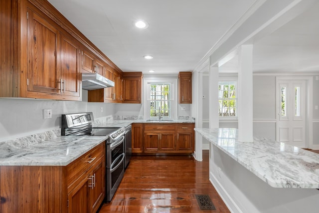 kitchen with stainless steel appliances, sink, light stone counters, and dark hardwood / wood-style floors