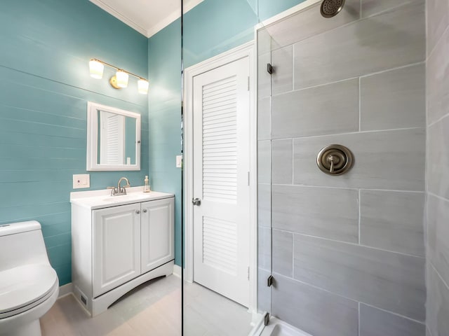 bathroom featuring crown molding, vanity, toilet, and a tile shower