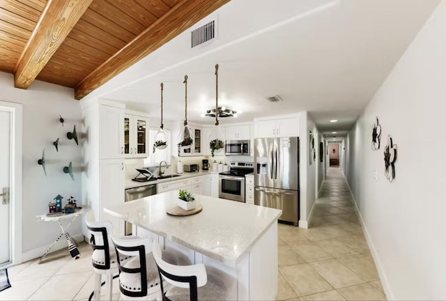 kitchen with sink, white cabinetry, decorative light fixtures, a center island, and appliances with stainless steel finishes