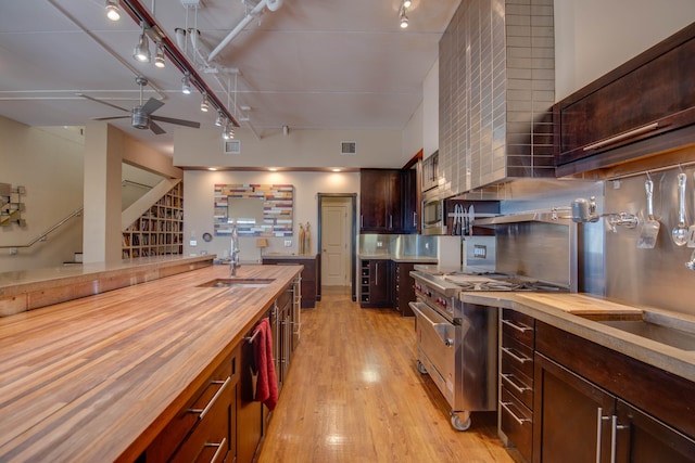 kitchen featuring appliances with stainless steel finishes, sink, butcher block countertops, and light hardwood / wood-style floors