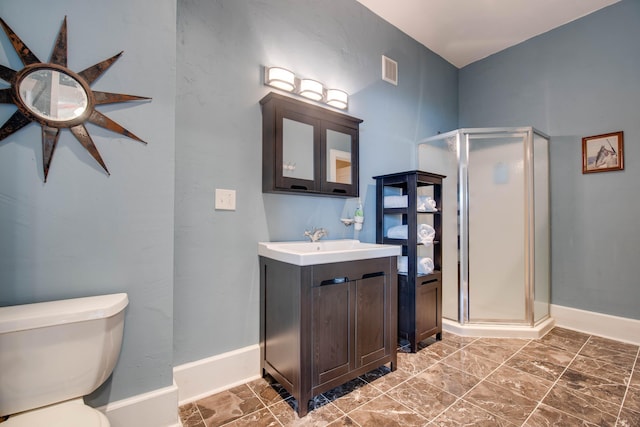 bathroom featuring vanity, toilet, and an enclosed shower