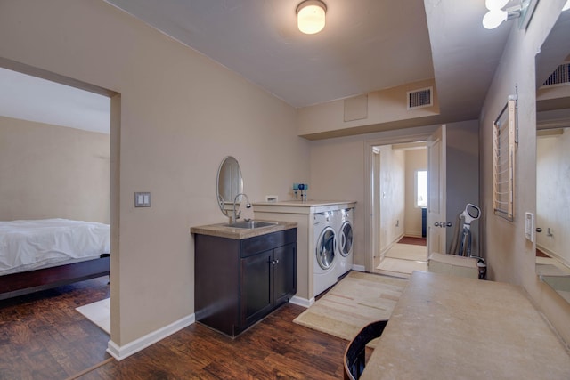 washroom with dark wood-type flooring, cabinets, separate washer and dryer, and sink