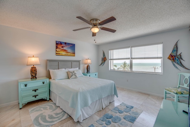 1901 S Roosevelt Blvd Unit 404S, Key West, FL 33040 - bedroom featuring light tile patterned flooring, a textured ceiling, ceiling fan, and baseboards