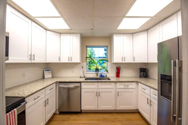 1901 S Roosevelt Blvd Unit 404S, Key West, FL 33040 - kitchen featuring stainless steel appliances, light wood-style floors, tasteful backsplash, white cabinetry, and a drop ceiling