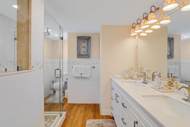 200 Wrenn Street Ph 701, Tavernier, FL 33070 - full bath featuring tile walls, a stall shower, wood finished floors, a wainscoted wall, and double vanity