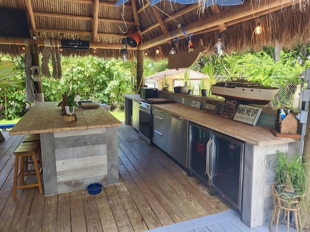 view of patio with exterior bar, a wooden deck, ceiling fan, and a gazebo