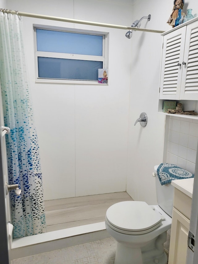 bathroom featuring walk in shower, vanity, and toilet