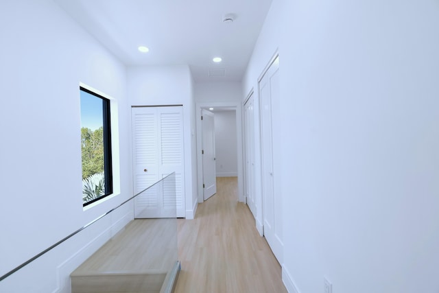 hallway featuring recessed lighting, baseboards, and light wood-style floors