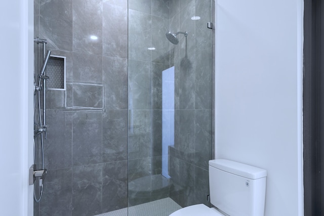 full bath featuring tiled shower and toilet