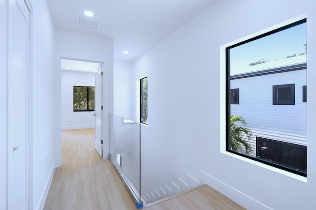 hallway with visible vents, recessed lighting, light wood-type flooring, and baseboards