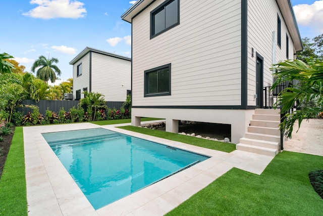 back of house with a patio, a yard, fence, and a fenced in pool