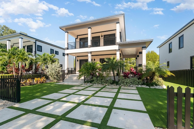 back of house with a patio, a balcony, fence, and a lawn