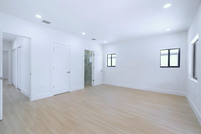 spare room featuring light wood-style floors, recessed lighting, visible vents, and baseboards