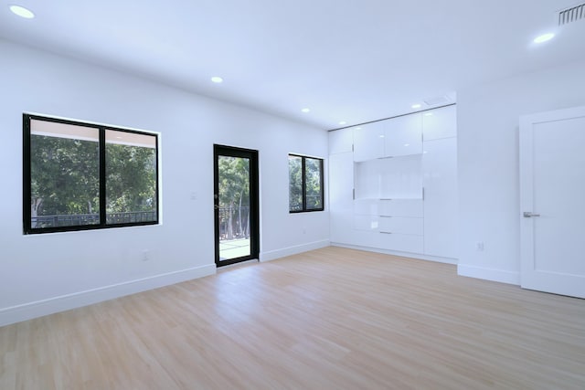 unfurnished room featuring light wood-style floors, recessed lighting, visible vents, and baseboards