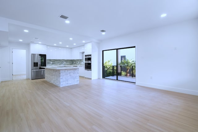 kitchen featuring visible vents, modern cabinets, a kitchen island, appliances with stainless steel finishes, and white cabinets