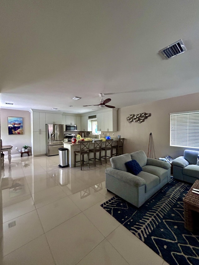 living room with light tile patterned floors and ceiling fan