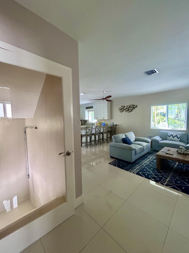 interior space with ceiling fan, tile patterned floors, and a wealth of natural light